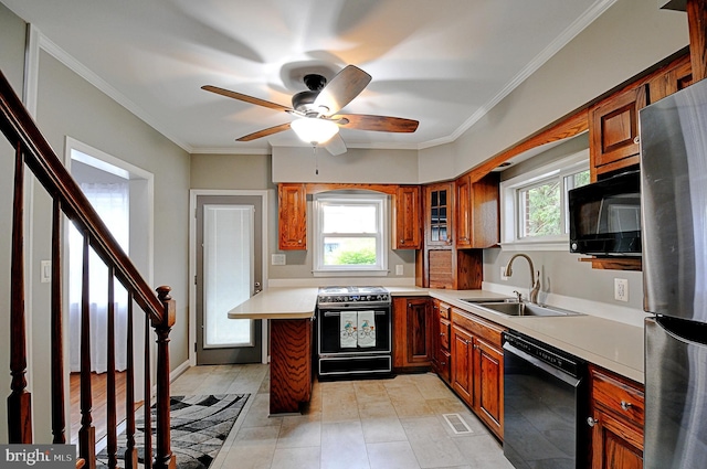 kitchen with a ceiling fan, a sink, brown cabinetry, black appliances, and light countertops