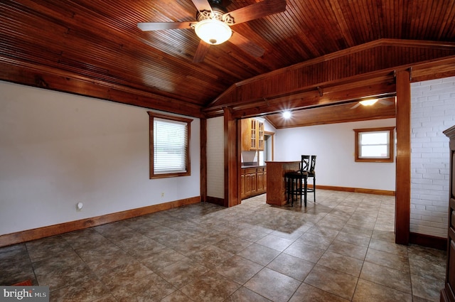 interior space with baseboards, vaulted ceiling, wooden ceiling, and ceiling fan