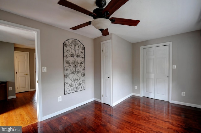 unfurnished bedroom with baseboards, a ceiling fan, wood finished floors, and a closet