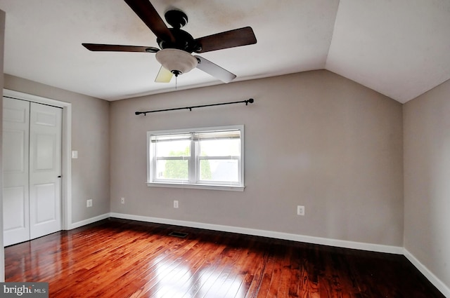 unfurnished bedroom with vaulted ceiling, a ceiling fan, hardwood / wood-style flooring, baseboards, and visible vents