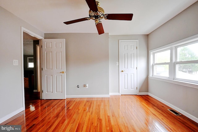 unfurnished bedroom with baseboards, a ceiling fan, light wood-style floors, and visible vents