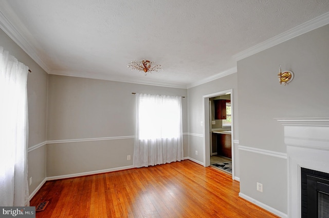 unfurnished living room featuring baseboards, visible vents, light wood finished floors, and a fireplace