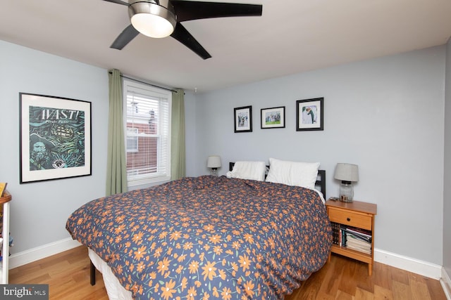 bedroom with baseboards, ceiling fan, and wood finished floors
