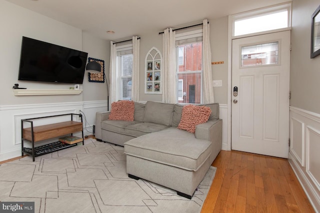 living area featuring wood finished floors and wainscoting