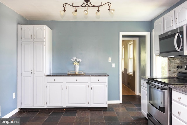 7012 Lancaster Rd, Baltimore, MD 21207 - kitchen with stainless steel appliances, white cabinets, decorative backsplash, and dark stone finish floors