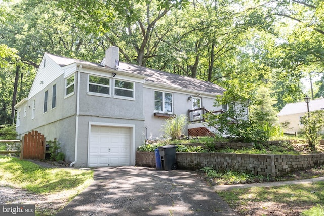 7012 Lancaster Rd, Baltimore, MD 21207 - view of front of house featuring a garage, asphalt driveway, a chimney, and stucco siding