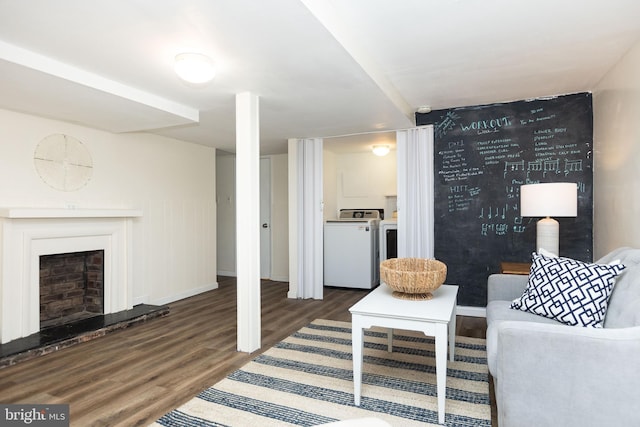 7012 Lancaster Rd, Baltimore, MD 21207 - living room with independent washer and dryer, wood finished floors, and a fireplace with raised hearth