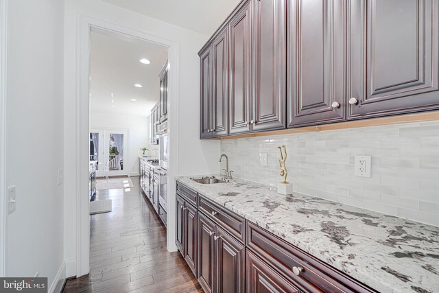 24642 Black Willow Dr, Aldie, VA 20105 - kitchen featuring light stone countertops, tasteful backsplash, a sink, french doors, and hardwood / wood-style flooring