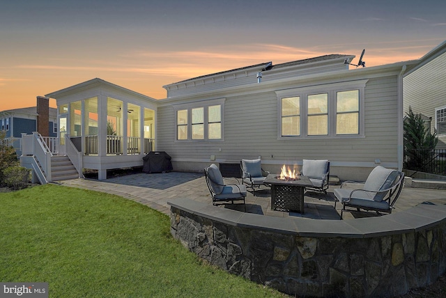 24642 Black Willow Dr, Aldie, VA 20105 - back of property at dusk featuring an outdoor fire pit, a patio area, and a lawn