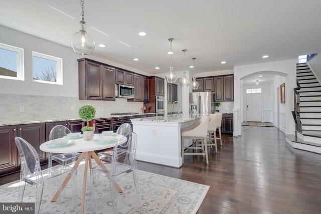 24642 Black Willow Dr, Aldie, VA 20105 - dining area with arched walkways, dark wood-style flooring, stairway, and recessed lighting