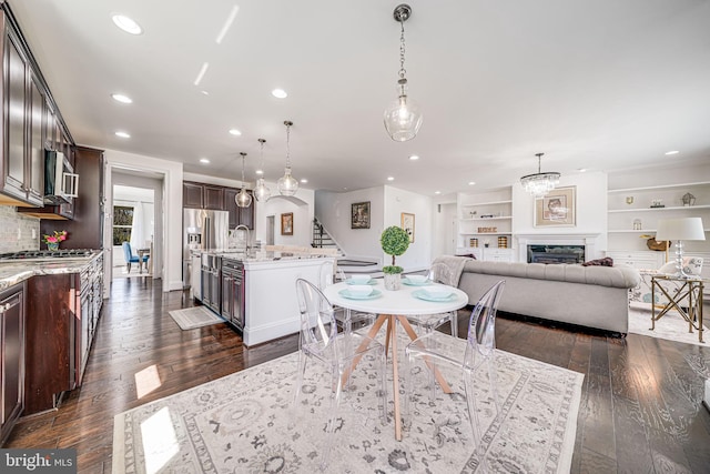 24642 Black Willow Dr, Aldie, VA 20105 - dining area with dark wood-type flooring, recessed lighting, a fireplace, and stairs