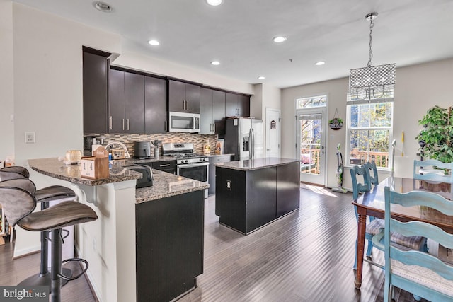 521 White Oak Dr, Glen Burnie, MD 21060 - kitchen featuring dark wood-type flooring, a center island, backsplash, and appliances with stainless steel finishes