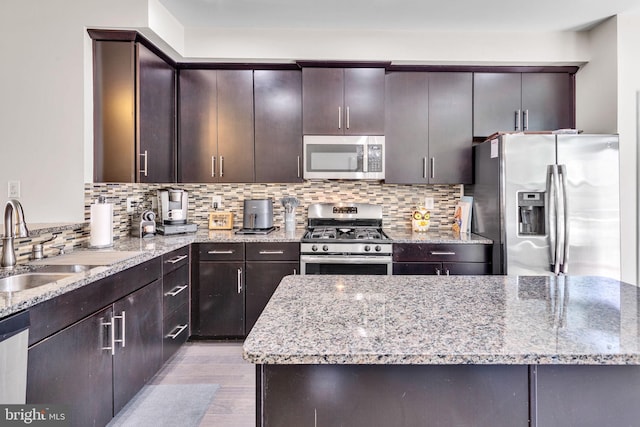 521 White Oak Dr, Glen Burnie, MD 21060 - kitchen with a sink, appliances with stainless steel finishes, dark brown cabinetry, light stone countertops, and backsplash