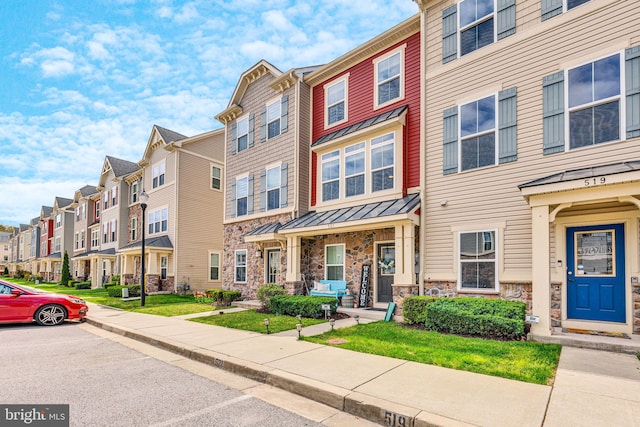 521 White Oak Dr, Glen Burnie, MD 21060 - townhome / multi-family property with stone siding, a standing seam roof, a residential view, and metal roof