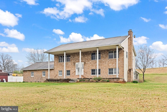 view of front of property featuring a chimney, fence, a front lawn, and brick siding