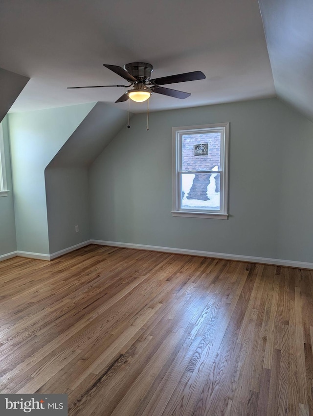 bonus room featuring baseboards, lofted ceiling, wood finished floors, and a ceiling fan