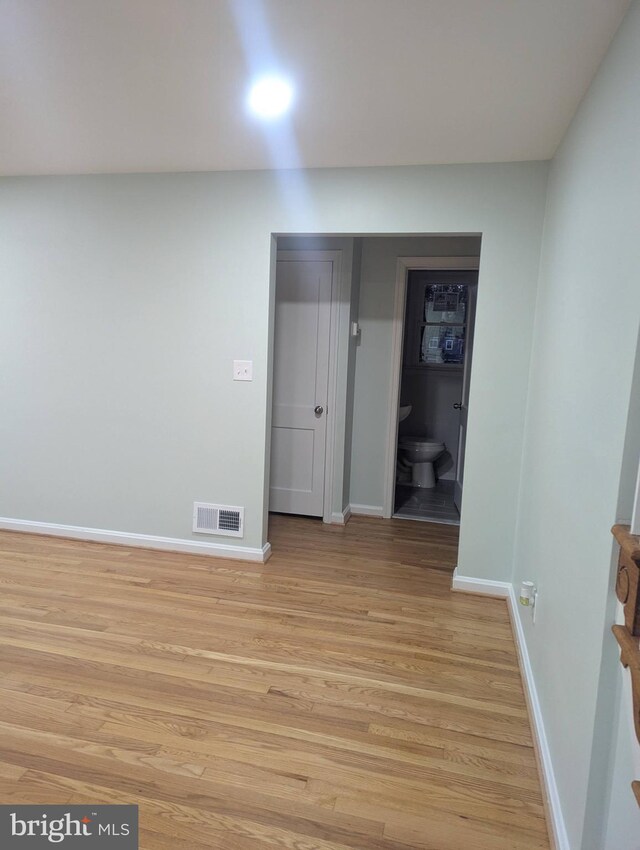 spare room with baseboards, visible vents, and light wood-type flooring