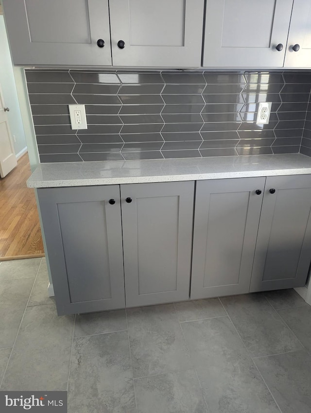details featuring gray cabinets, light countertops, and decorative backsplash