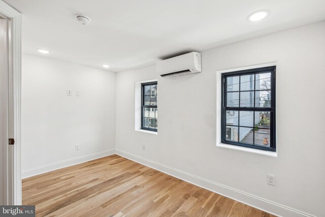 1129 E Berks St, Philadelphia, PA 19125 - empty room with a wealth of natural light, light wood-style floors, an AC wall unit, and baseboards