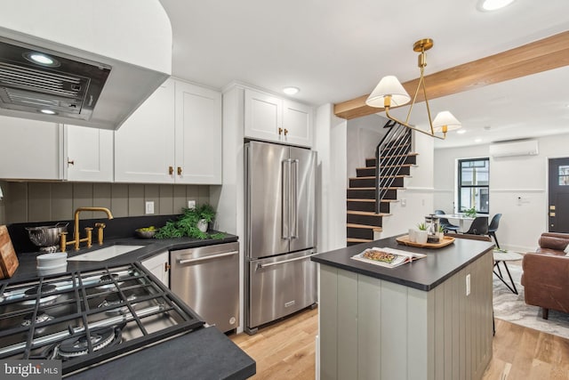 1129 E Berks St, Philadelphia, PA 19125 - kitchen with dark countertops, appliances with stainless steel finishes, a sink, ventilation hood, and a wall unit AC