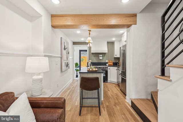1129 E Berks St, Philadelphia, PA 19125 - kitchen featuring white cabinetry, premium appliances, light wood-style flooring, custom exhaust hood, and dark countertops
