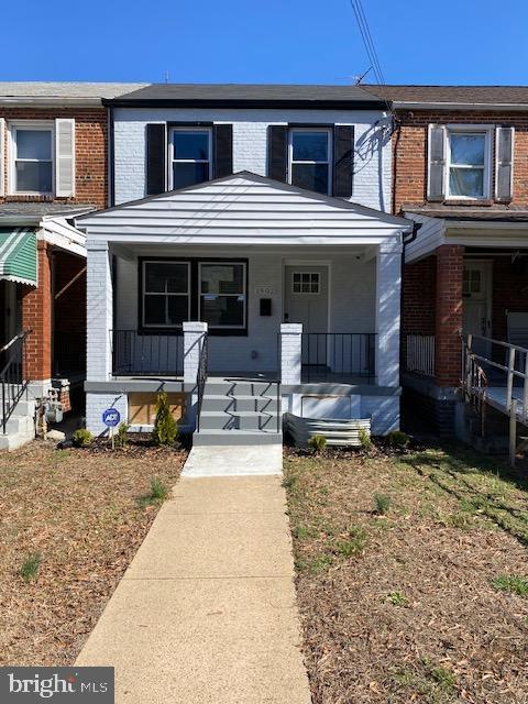 multi unit property with brick siding and a porch