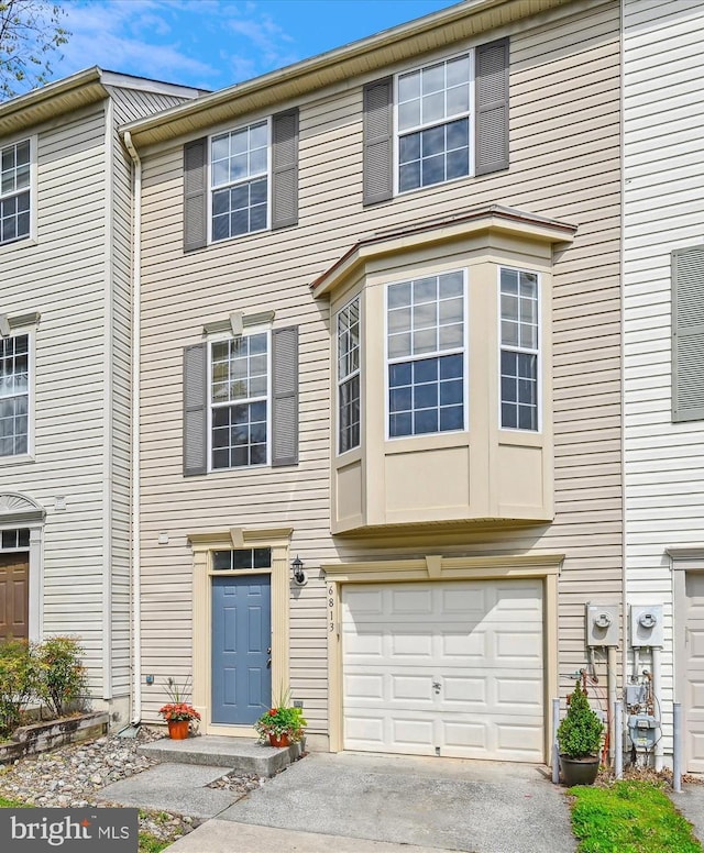 multi unit property featuring driveway and a garage