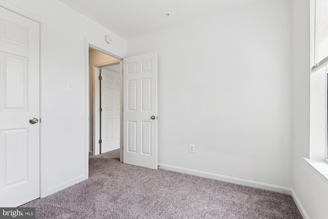 unfurnished bedroom featuring baseboards and carpet