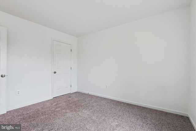 unfurnished room featuring baseboards and carpet