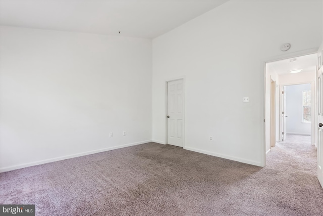 unfurnished room with baseboards and carpet flooring
