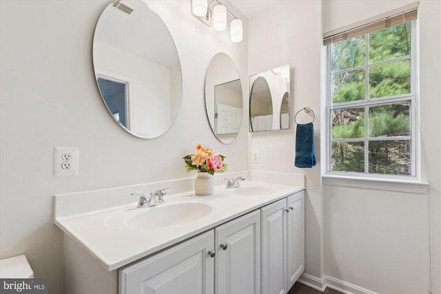 bathroom featuring visible vents, a sink, and double vanity