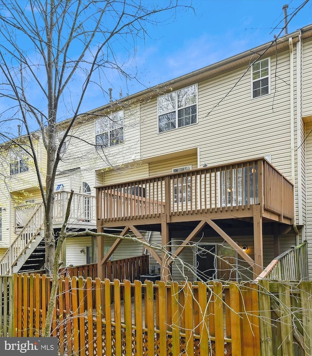 rear view of property featuring a wooden deck and fence private yard