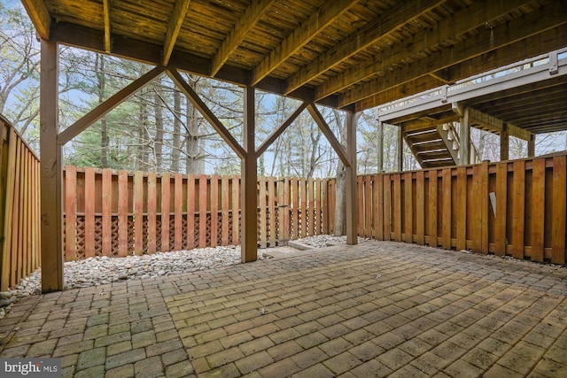 view of patio / terrace featuring fence and stairway