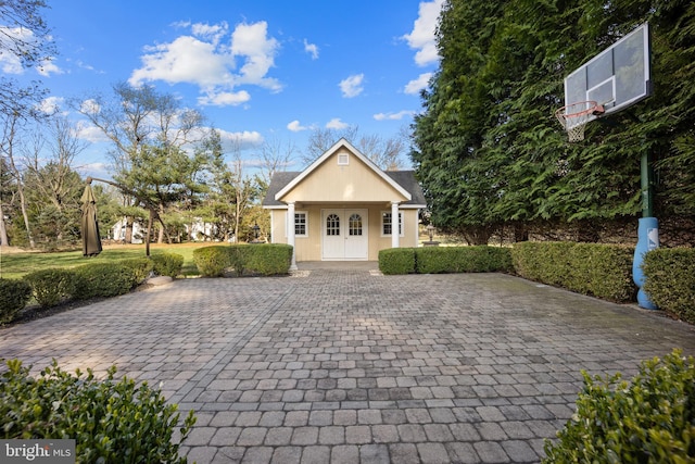 view of front facade featuring a front lawn, decorative driveway, and a shingled roof