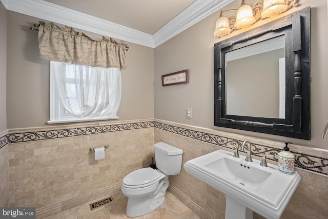 half bath with wainscoting, tile walls, ornamental molding, and toilet