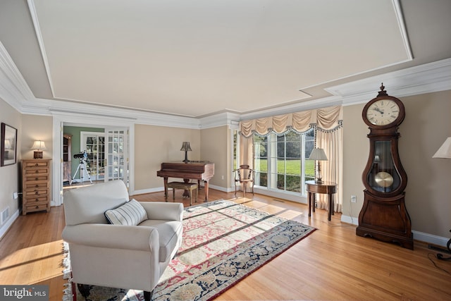 living area featuring french doors, baseboards, ornamental molding, and wood finished floors
