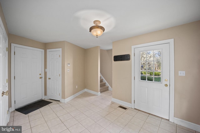 foyer featuring visible vents, baseboards, and stairs