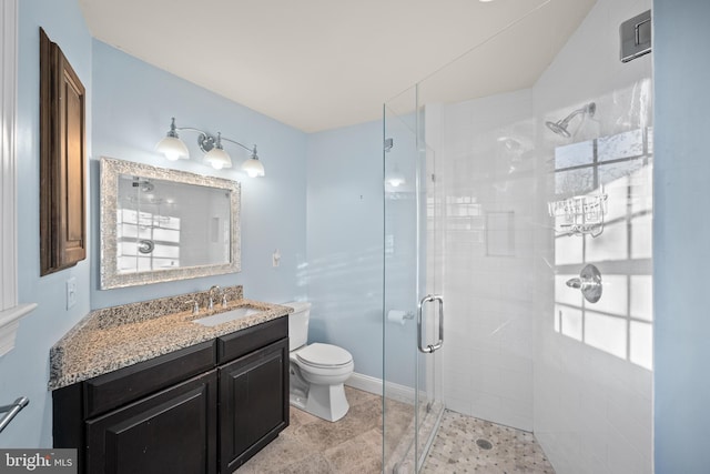 bathroom with a shower stall, vanity, and toilet