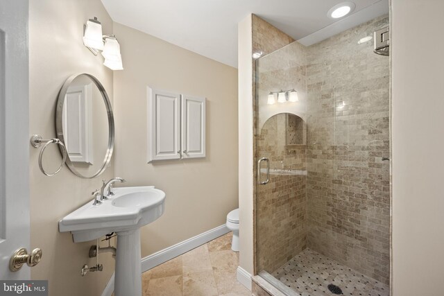 bathroom featuring a shower stall, baseboards, and toilet