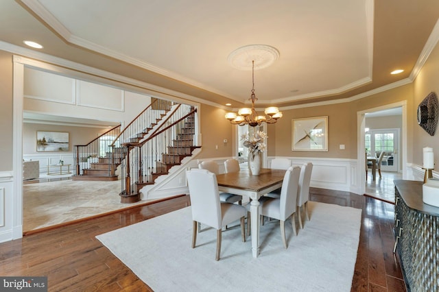 18102 Eaglesham Ct, Leesburg, VA 20175 - dining space featuring a tray ceiling, dark wood finished floors, stairway, a chandelier, and a decorative wall