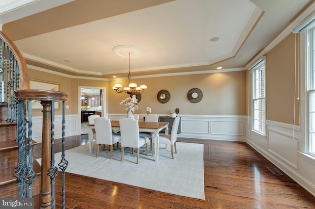 18102 Eaglesham Ct, Leesburg, VA 20175 - dining area with a decorative wall, dark wood-type flooring, a chandelier, wainscoting, and crown molding