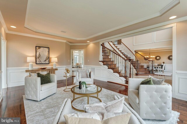 18102 Eaglesham Ct, Leesburg, VA 20175 - living area with stairway, a chandelier, wood finished floors, a decorative wall, and a raised ceiling