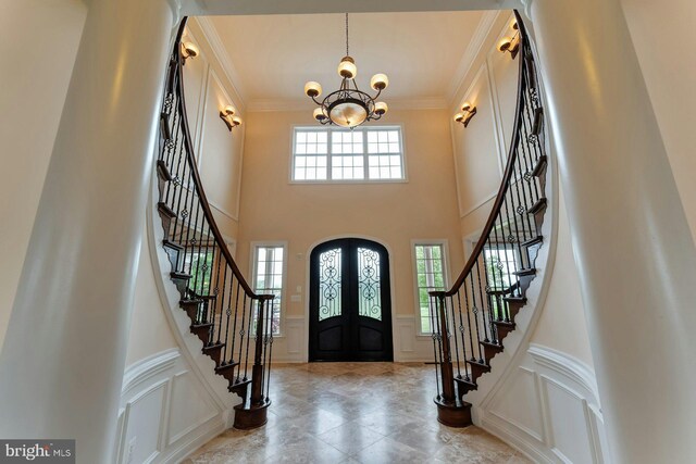 18102 Eaglesham Ct, Leesburg, VA 20175 - foyer entrance featuring a decorative wall, french doors, a chandelier, stairs, and crown molding