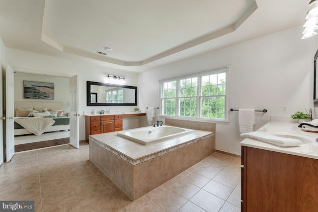 18102 Eaglesham Ct, Leesburg, VA 20175 - ensuite bathroom with a tray ceiling, tile patterned floors, two vanities, a bath, and baseboards