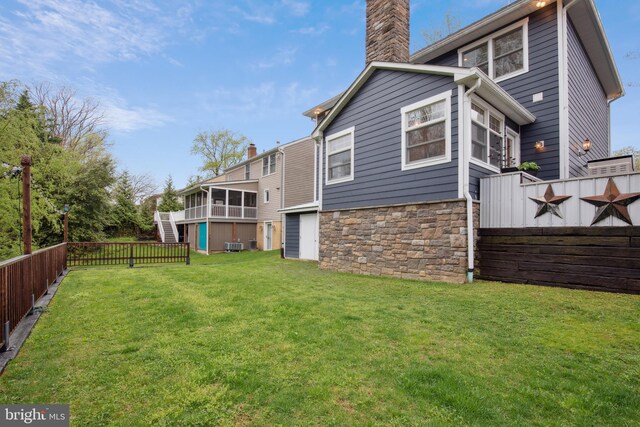 810 Macsherry Dr, Arnold, MD 21012 - back of property with a sunroom, a yard, fence, stone siding, and a chimney