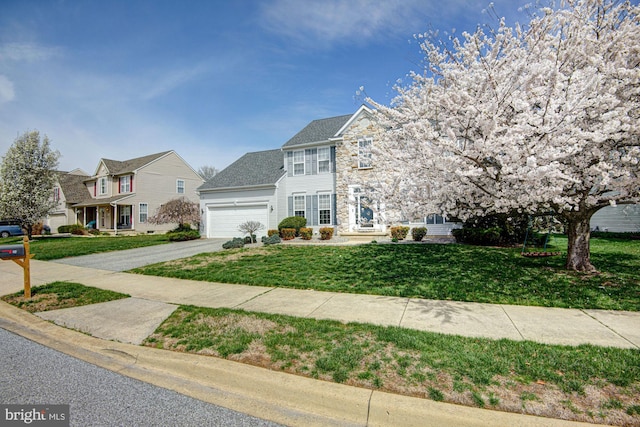 24 W Shakespeare Dr, Middletown, DE 19709 - colonial house featuring a garage, a front lawn, stone siding, and driveway