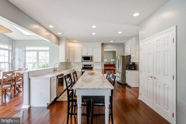 24 W Shakespeare Dr, Middletown, DE 19709 - kitchen featuring stainless steel appliances, a sink, a peninsula, dark wood-style floors, and white cabinetry