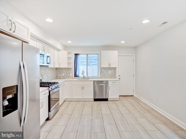 2671 Emerald St, Philadelphia, PA 19125 - kitchen with light countertops, appliances with stainless steel finishes, backsplash, and white cabinets