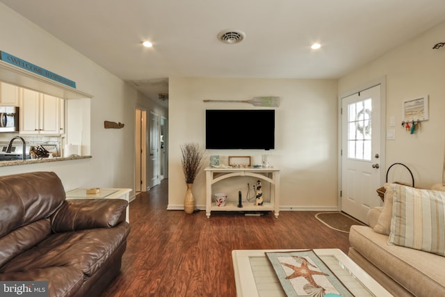 living room featuring baseboards, dark wood-style flooring, visible vents, and recessed lighting