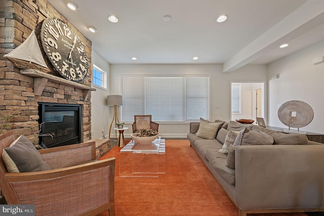 living area featuring a stone fireplace, baseboards, and recessed lighting